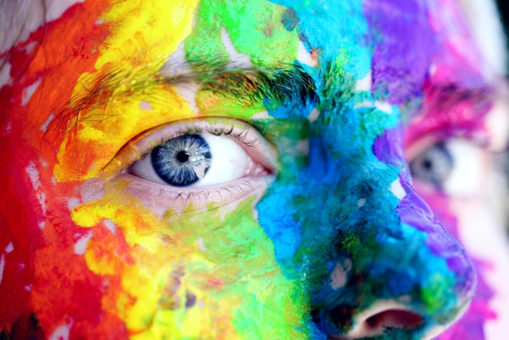 a colorful painted face illustrating Self-transformation through self-understanding