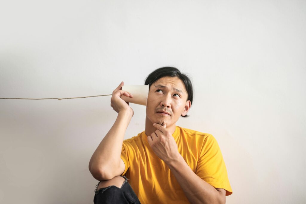 a man listening at a cup on a wire illustrating Piaget's Schema in requirements engineering