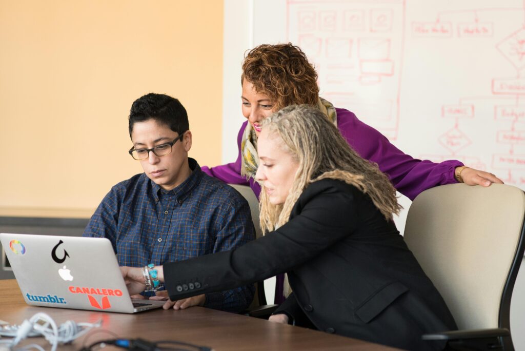 three people working and looking on a laptop screen illustrating elicitation activities in engineering
