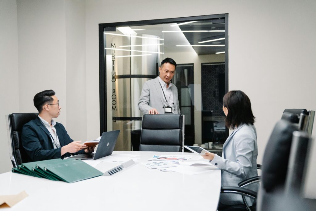 a business meeting with three people showing stakeholder management in requirements engineering