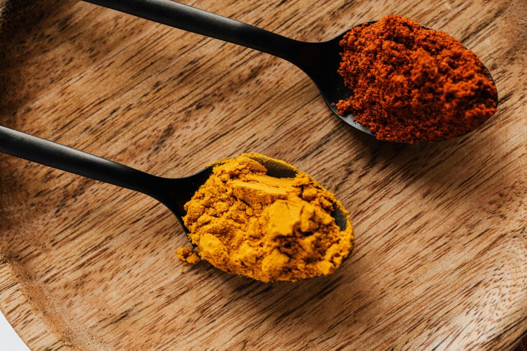 two spoons, one with kurkuma and one with peperoni powder representing conflicting requirements