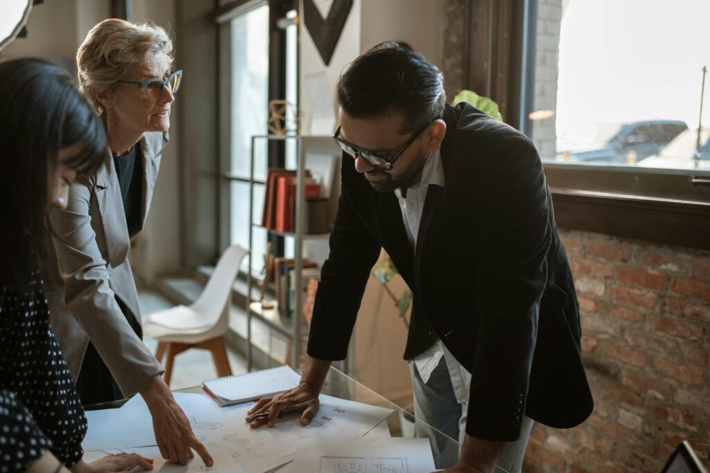 woman and man standing and looking on paper on a desk illustratring human behavior and requirements engineering