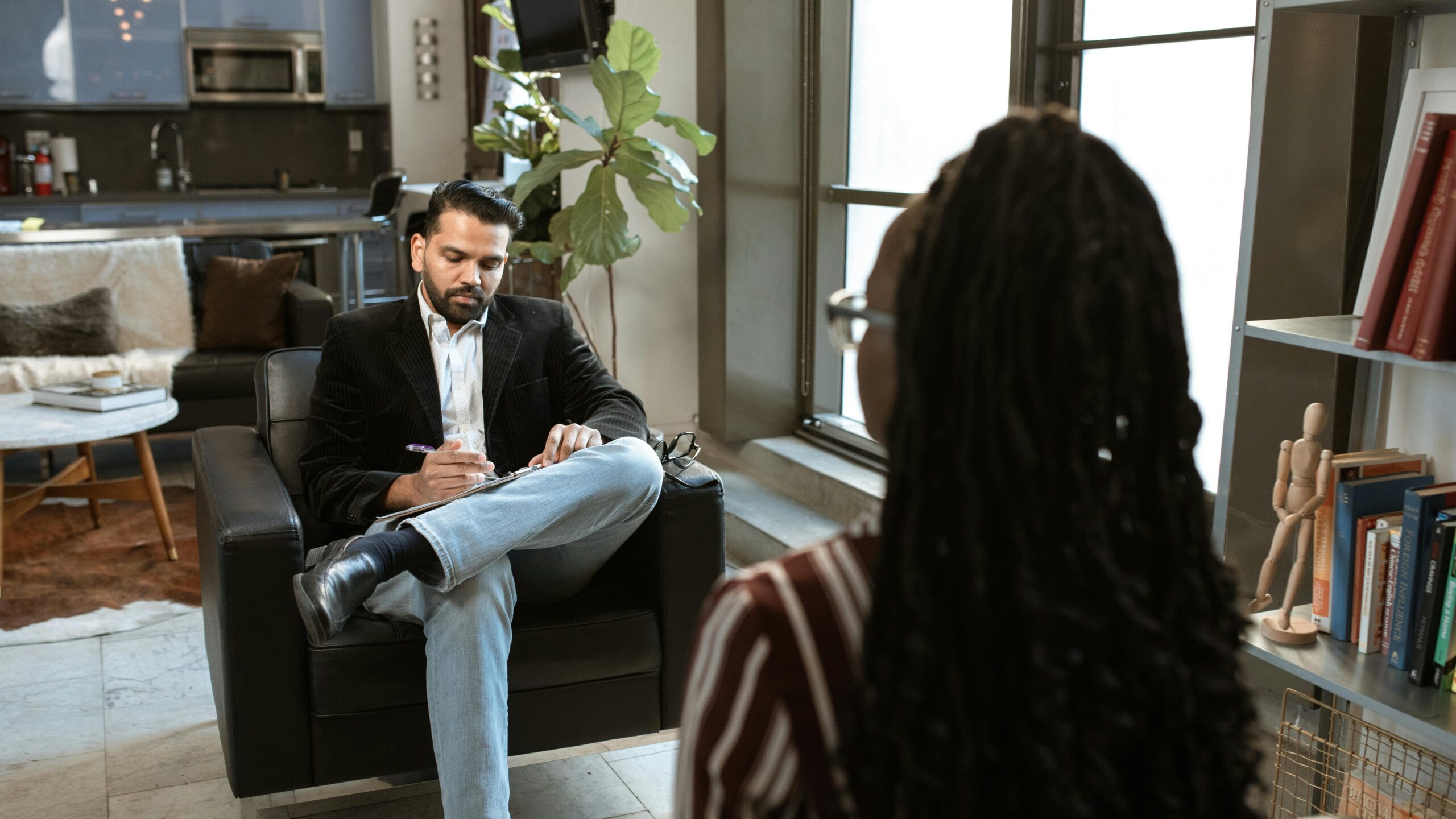 a man and woman sitting in front of each other illustrating Requirements Engineering Personality Analysis