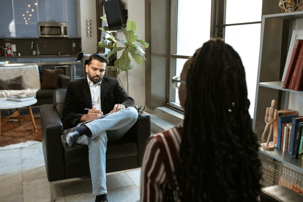 a man and woman sitting in front of each other illustrating Requirements Engineering Personality Analysis