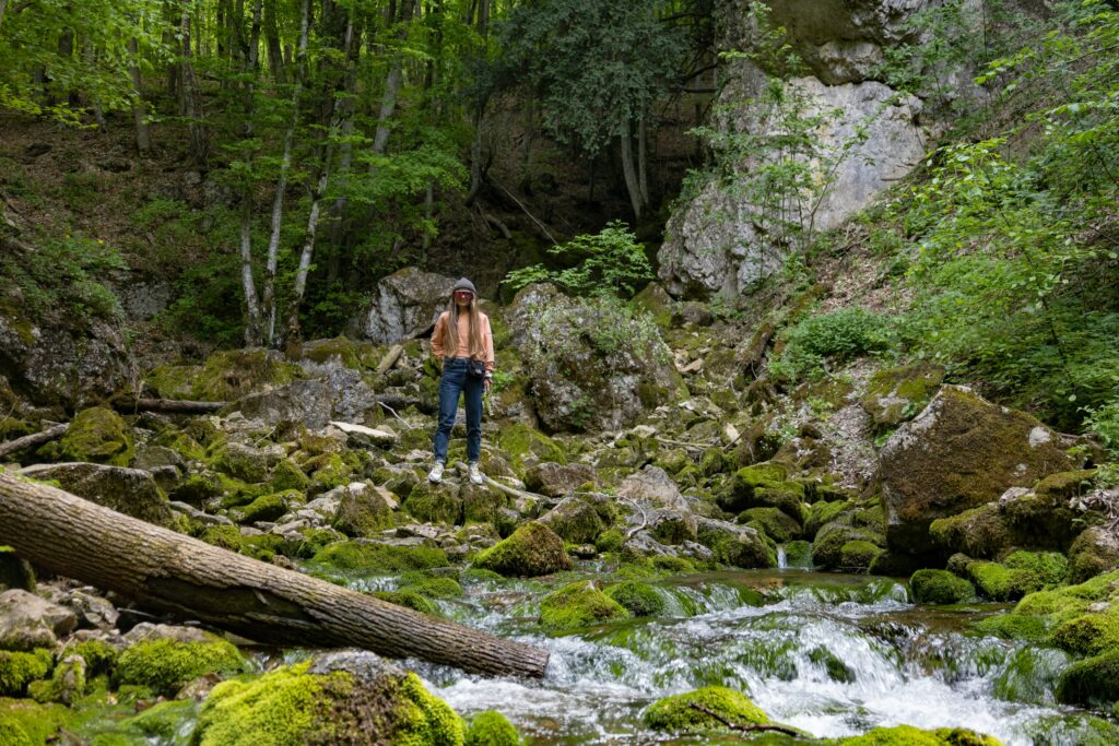 a woman standing on rock with water coming out as a water sources representing importance of requirements sources