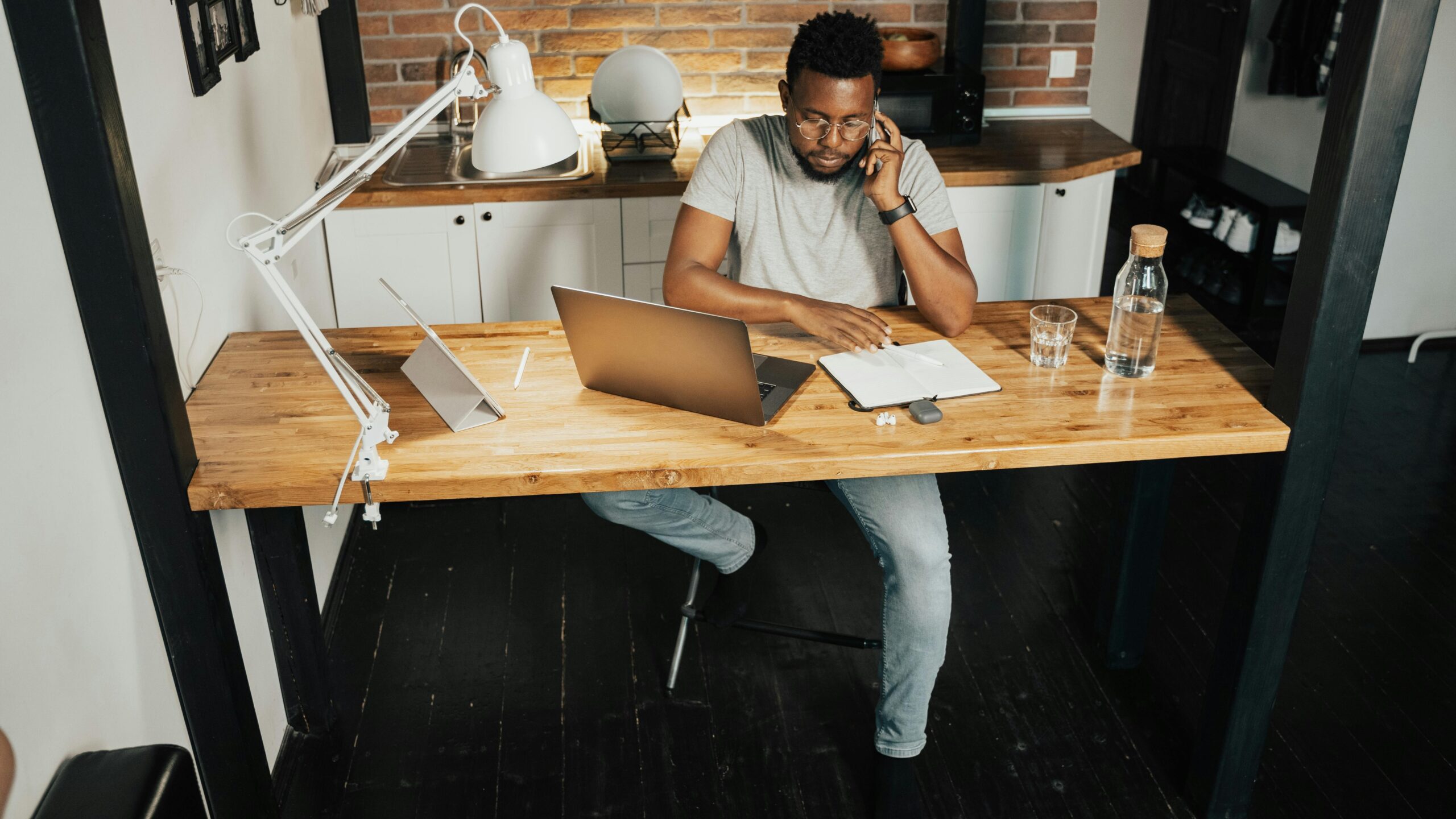 a man sitting on a computer desk talking on a phone representing elicitation techniques