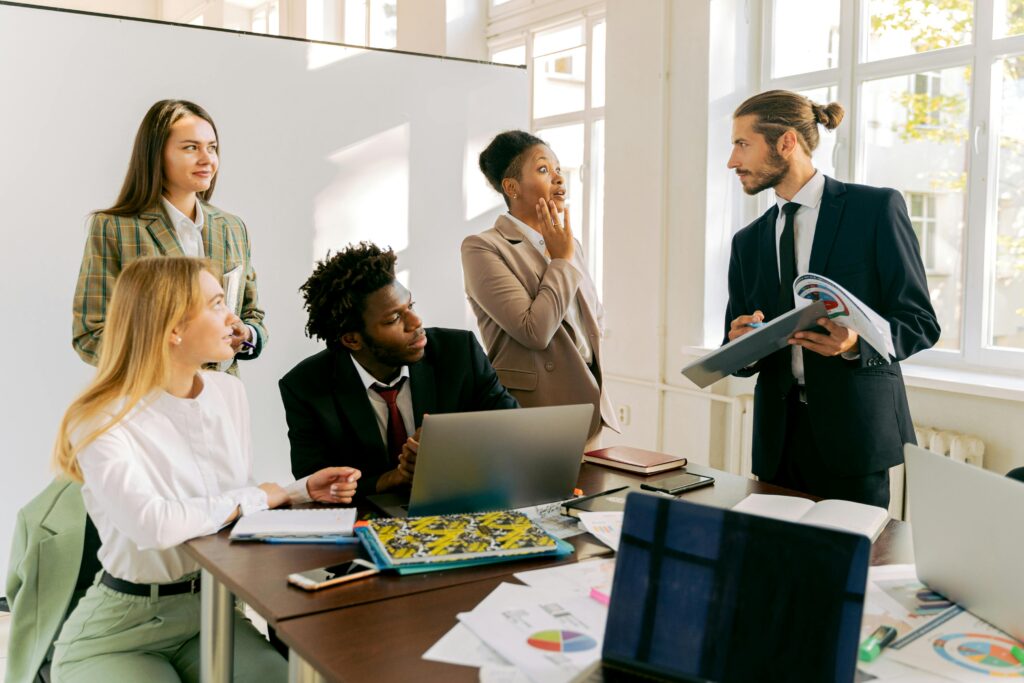 a man pitching showing paper to a bunch of business people illustrating negotiation requirements engineers