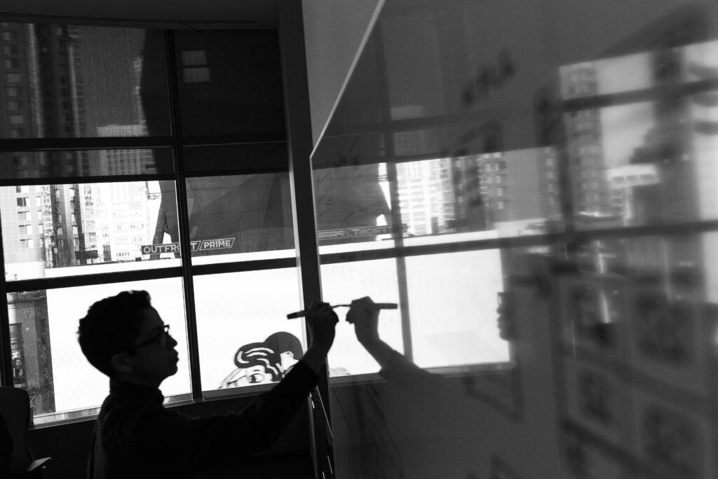 schemes of a man standing in fron of a whiteboard writing to represent Elicitation Objectives in Planning