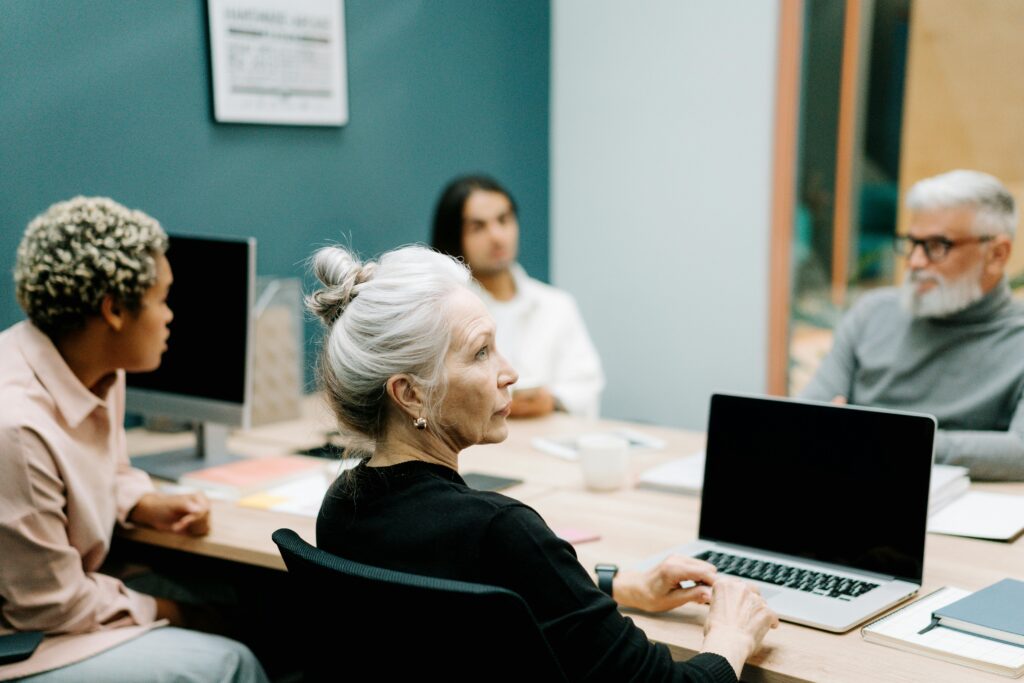 a team of four people sits at a table and discusses ITIL Service Design