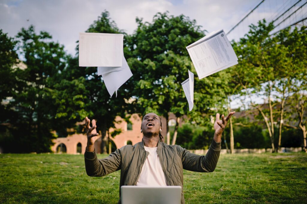 a man throws paper in the air laughing illustrating resolution result in requirements engineering