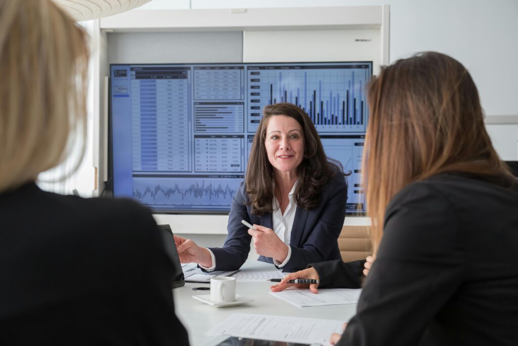 a woman presenting in front of a screen with graphs illustrating Stakeholder Compatibility